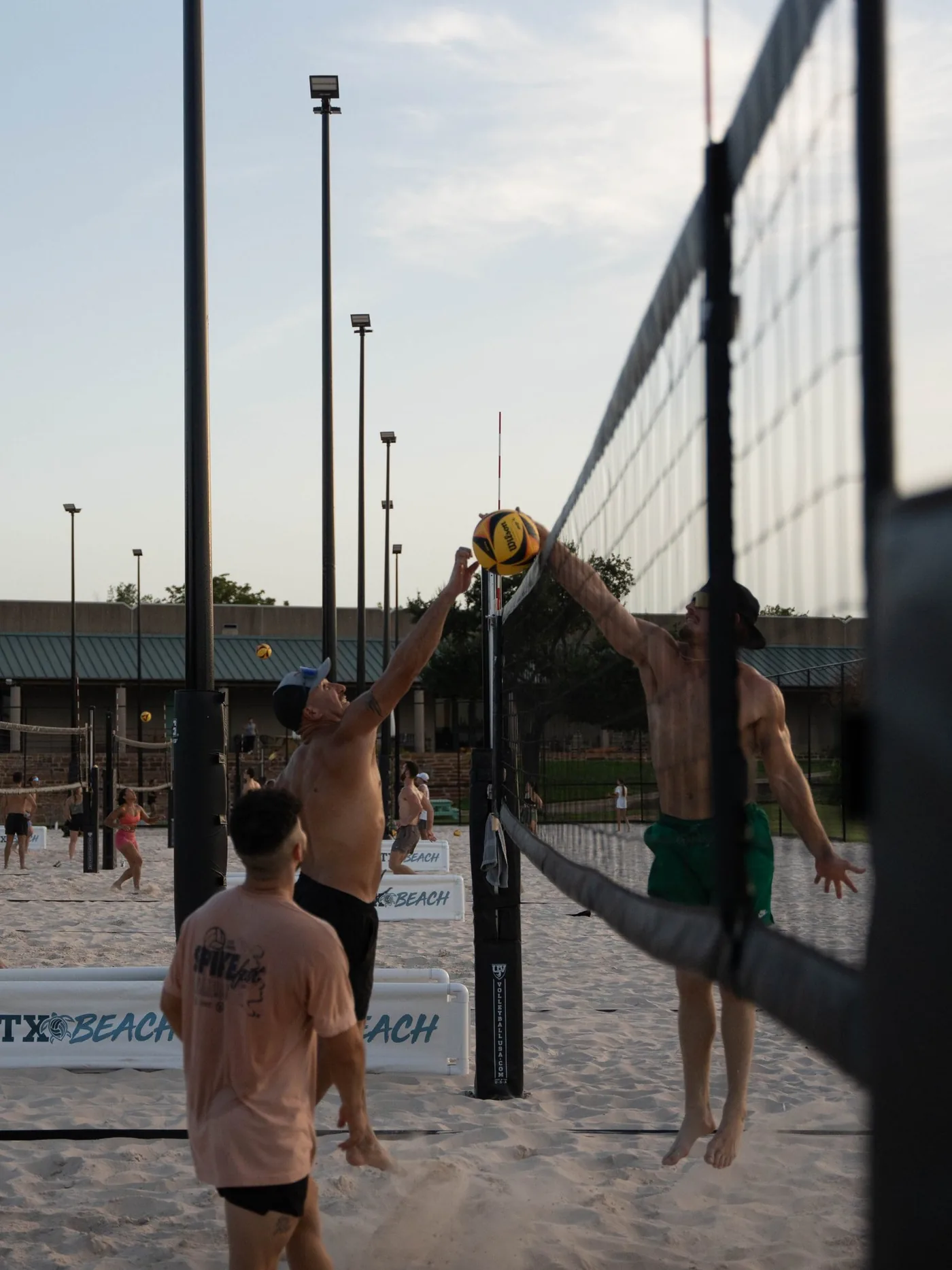 Sand volleyball rally at sunset